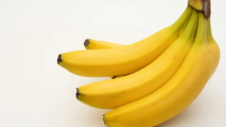 Ein Bund reifer gelber Bananen auf einem weißen Tisch