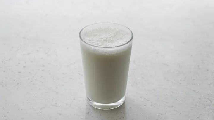 Ein Glas Milch auf einer hellen Steinoberfläche